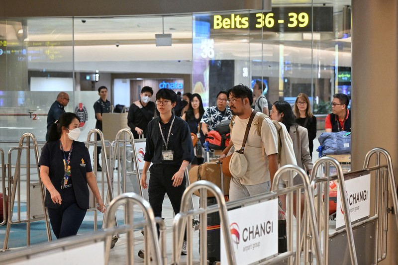 Penumpang pesawat SQ321 dari London yang mengalami turbulensi hebat yang mengakibatkan satu korban jiwa dan beberapa luka-luka serta melakukan pendaratan darurat di Bandara Suvarnabhumi di Bangkok, tiba di Bandara Changi di Singapura 22 Mei 2024. (SPH/The Straits Times/Ariffin Jamar via REUTERS)
