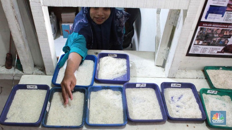 Petugas menata beras di pertokoan kawasan Pasar Minggu, Jakarta, Rabu, (22/5). Badan Pangan Nasional (Bapanas) mengeluarkan kebijakan relaksasi Harga Eceran Tertinggi (HET) untuk beras premium sebesar Rp 1.000 per kilogram (kg). Relaksasi HET beras premium ini diberlakukan sementara mulai 10 Maret sampai 23 Maret, menyasar 8 wilayah. (CNBC Indonesia/Muhammad Sabki)
