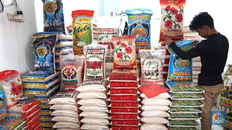Petugas menata beras di pertokoan kawasan Pasar Minggu, Jakarta, Rabu, (22/5). Badan Pangan Nasional (Bapanas) mengeluarkan kebijakan relaksasi Harga Eceran Tertinggi (HET) untuk beras premium sebesar Rp 1.000 per kilogram (kg). Relaksasi HET beras premium ini diberlakukan sementara mulai 10 Maret sampai 23 Maret, menyasar 8 wilayah. (CNBC Indonesia/Muhammad Sabki)