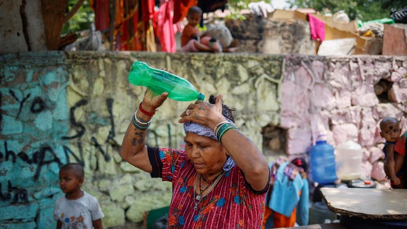 Panasnya cuaca di India membuat sejumlah warga melakukan berbagai cara untuk mendinginkan tubuhnya. (REUTERS/Adnan Abidi)