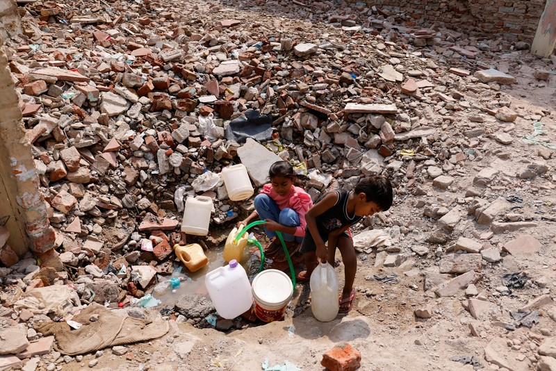 Panasnya cuaca di India membuat sejumlah warga melakukan berbagai cara untuk mendinginkan tubuhnya. (REUTERS/Adnan Abidi)