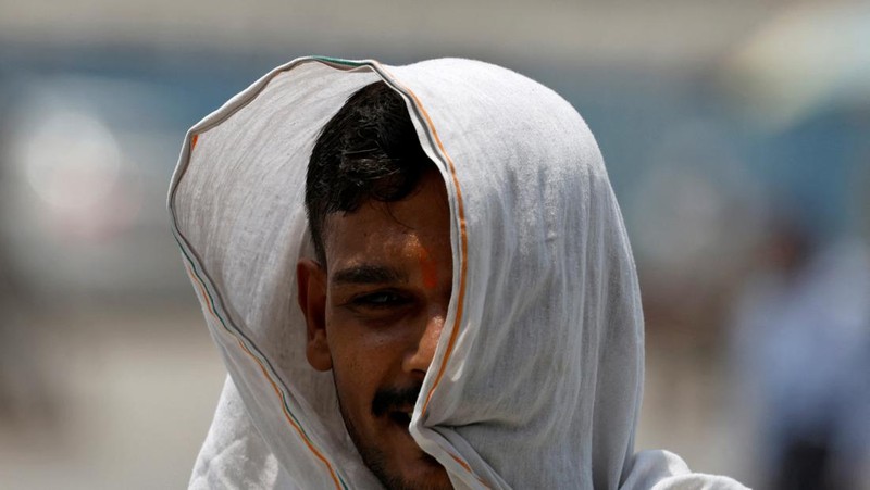 Panasnya cuaca di India membuat sejumlah warga melakukan berbagai cara untuk mendinginkan tubuhnya. (REUTERS/Adnan Abidi)