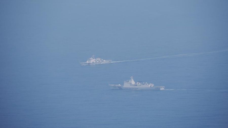 Seorang pelaut Taiwan di atas kapal Angkatan Laut melihat ke arah kapal perang Tiongkok saat bernavigasi di perairan lepas pantai barat Taiwan. (via REUTERS/TAIWAN DEFENCE MINISTRY)