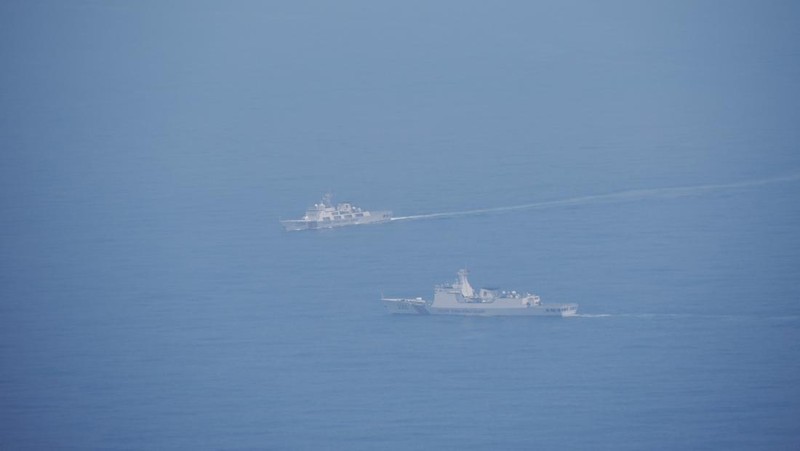 Seorang pelaut Taiwan di atas kapal Angkatan Laut melihat ke arah kapal perang Tiongkok saat bernavigasi di perairan lepas pantai barat Taiwan. (via REUTERS/TAIWAN DEFENCE MINISTRY)
