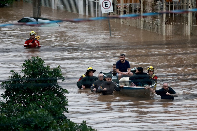 Orang-orang berjalan di daerah banjir di lingkungan Cavalhada setelah hujan lebat di Porto Alegre, Brasil 23 Mei 2024. (REUTERS/Diego Vara)