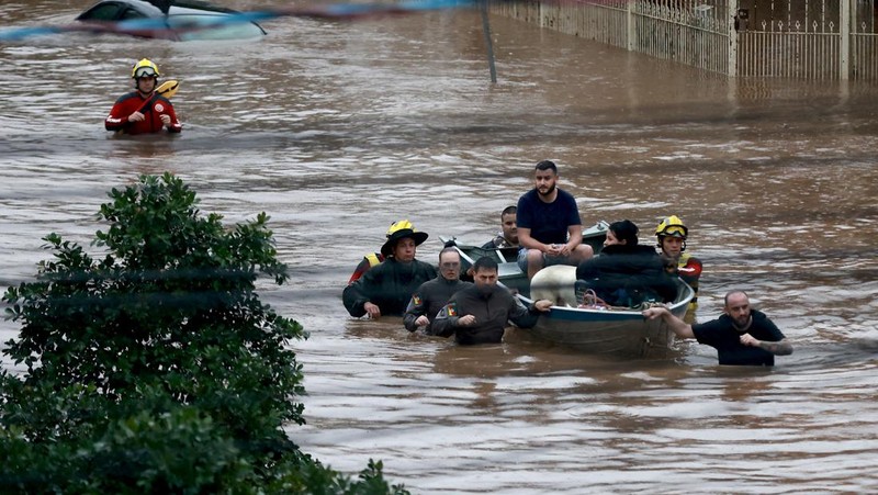 Orang-orang berjalan di daerah banjir di lingkungan Cavalhada setelah hujan lebat di Porto Alegre, Brasil 23 Mei 2024. (REUTERS/Diego Vara)