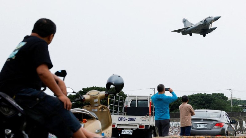 Seorang pelaut Taiwan di atas kapal Angkatan Laut melihat ke arah kapal perang Tiongkok saat bernavigasi di perairan lepas pantai barat Taiwan. (via REUTERS/TAIWAN DEFENCE MINISTRY)