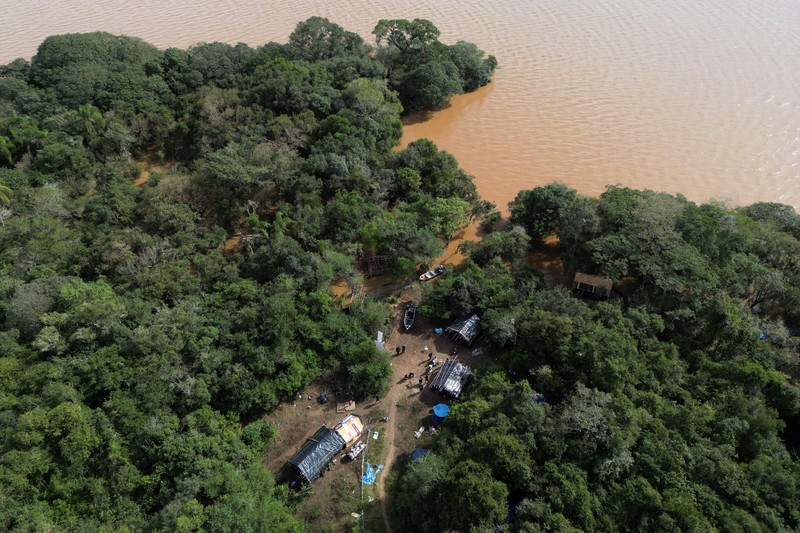 Orang-orang berjalan di daerah banjir di lingkungan Cavalhada setelah hujan lebat di Porto Alegre, Brasil 23 Mei 2024. (REUTERS/Diego Vara)
