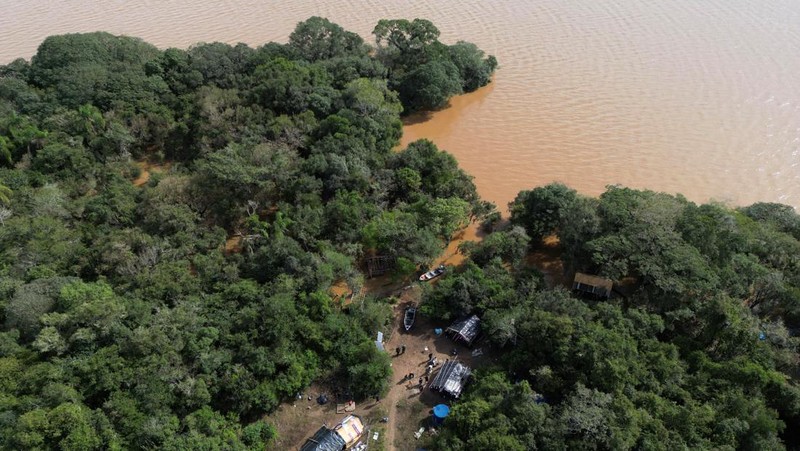 Orang-orang berjalan di daerah banjir di lingkungan Cavalhada setelah hujan lebat di Porto Alegre, Brasil 23 Mei 2024. (REUTERS/Diego Vara)