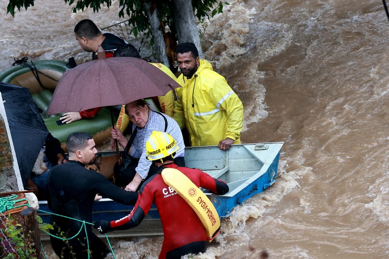 Orang-orang berjalan di daerah banjir di lingkungan Cavalhada setelah hujan lebat di Porto Alegre, Brasil 23 Mei 2024. (REUTERS/Diego Vara)