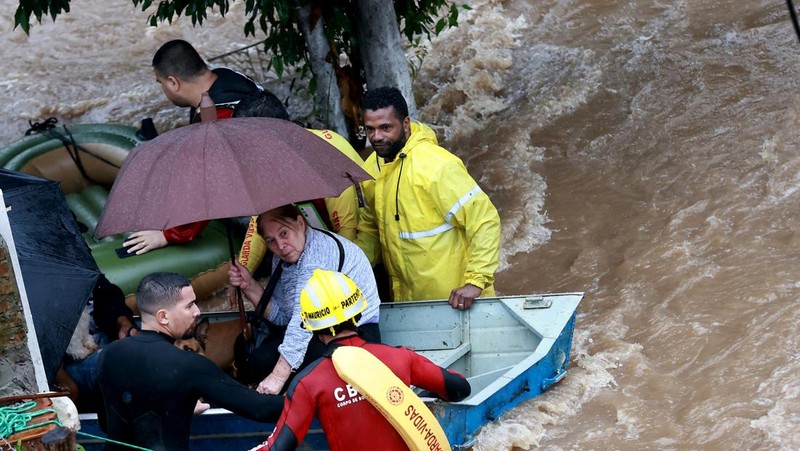 Orang-orang berjalan di daerah banjir di lingkungan Cavalhada setelah hujan lebat di Porto Alegre, Brasil 23 Mei 2024. (REUTERS/Diego Vara)