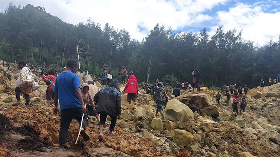 Penduduk setempat berkumpul dan mencari korban di tengah kerusakan akibat tanah longsor di Maip Mulitaka, provinsi Enga, Papua Nugini 24 Mei 2024. (AP/Benjamin Sipa)