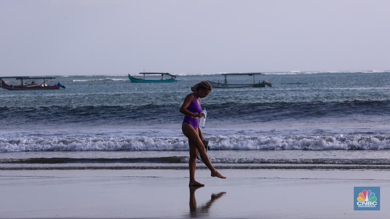 Wisatawan mancanegara beraktivitas di Pantai Kuta, Denpasar, Bali, Sabtu (25/5/2024). Pantai Kuta masih menjadi primadona wisatawan mancanegara yang berkunjung ke Bali. (CNBC Indonesia/Faisal Rahman)