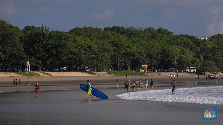 Wisatawan mancanegara beraktivitas di Pantai Kuta, Denpasar, Bali, Sabtu (25/5/2024). Pantai Kuta masih menjadi primadona wisatawan mancanegara yang berkunjung ke Bali. (CNBC Indonesia/Faisal Rahman)