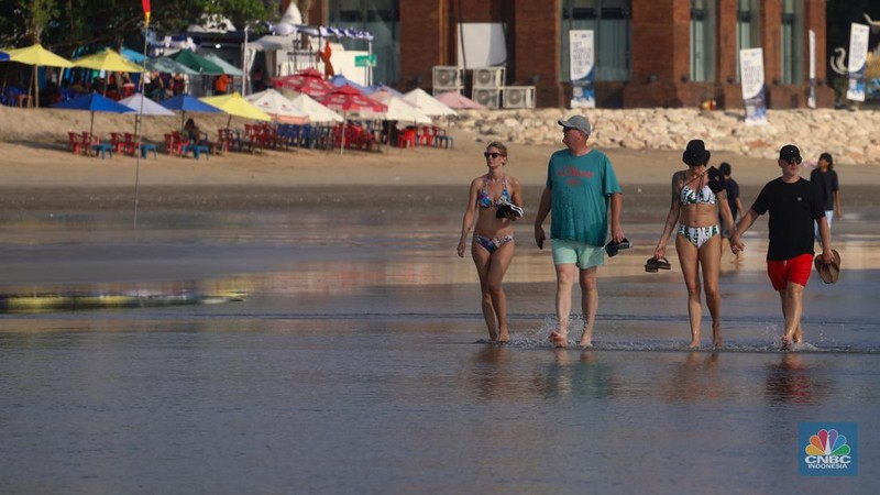 Wisatawan mancanegara beraktivitas di Pantai Kuta, Denpasar, Bali, Sabtu (25/5/2024). Pantai Kuta masih menjadi primadona wisatawan mancanegara yang berkunjung ke Bali. (CNBC Indonesia/Faisal Rahman)