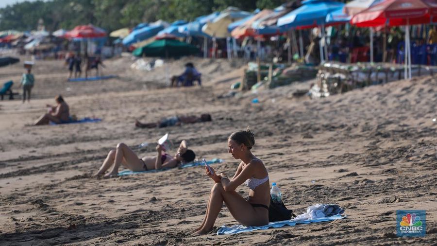 Wisatawan mancanegara beraktivitas di Pantai Kuta, Denpasar, Bali, Sabtu (25/5/2024). Pantai Kuta masih menjadi primadona wisatawan mancanegara yang berkunjung ke Bali. (CNBC Indonesia/Faisal Rahman)