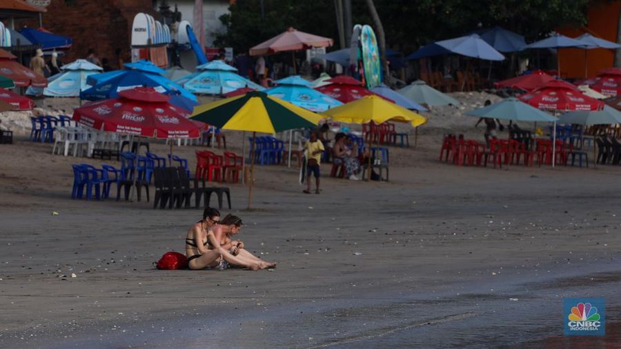 Wisatawan mancanegara beraktivitas di Pantai Kuta, Denpasar, Bali, Sabtu (25/5/2024). Pantai Kuta masih menjadi primadona wisatawan mancanegara yang berkunjung ke Bali. (CNBC Indonesia/Faisal Rahman)