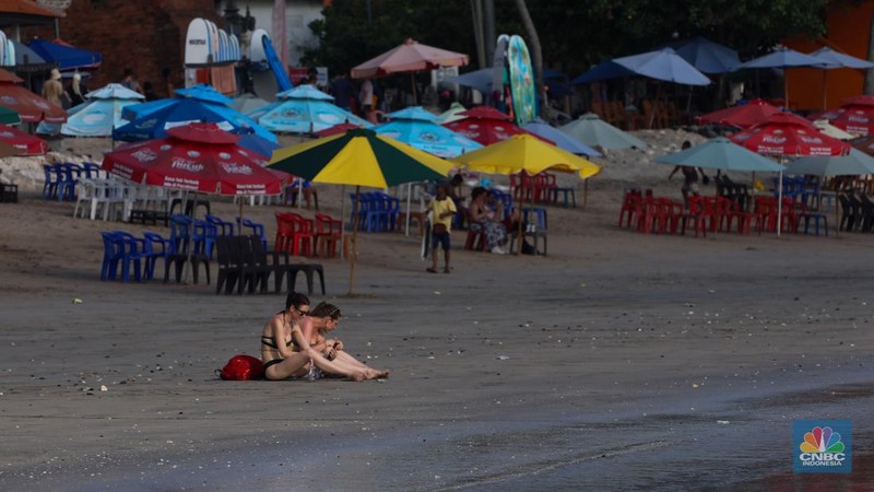 Wisatawan mancanegara beraktivitas di Pantai Kuta, Denpasar, Bali, Sabtu (25/5/2024). Pantai Kuta masih menjadi primadona wisatawan mancanegara yang berkunjung ke Bali. (CNBC Indonesia/Faisal Rahman)