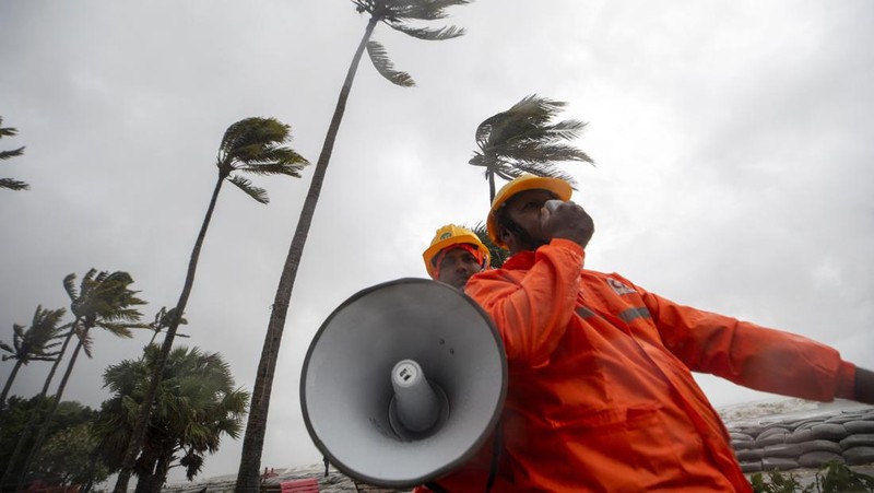 Seorang pria menyelamatkan gerobak dan material lainnya saat air mengalir ke pantai Kuakata di pesisir Teluk Benggala akibat mendekatnya Topan Remal di Barisal, Bangladesh, Minggu, 26 Mei 2024. (AP Photo/Abdul Goni)