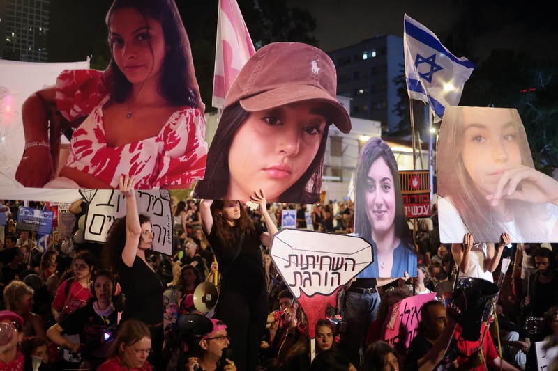 Seorang pengunjuk rasa menyalakan suar ketika mereka berdiri di dekat api yang menyala selama protes terhadap pemerintahan Perdana Menteri Israel Benjamin Netanyahu dan menyerukan pembebasan sandera yang diculik dalam serangan mematikan terhadap Israel pada 7 Oktober oleh kelompok Islam Palestina Hamas, di Tel Aviv , Israel, 25 Mei 2024. (REUTERS/Marko Djurica)