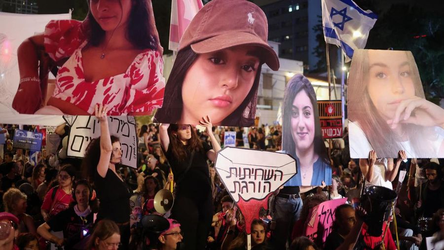 Seorang pengunjuk rasa menyalakan suar ketika mereka berdiri di dekat api yang menyala selama protes terhadap pemerintahan Perdana Menteri Israel Benjamin Netanyahu dan menyerukan pembebasan sandera yang diculik dalam serangan mematikan terhadap Israel pada 7 Oktober oleh kelompok Islam Palestina Hamas, di Tel Aviv , Israel, 25 Mei 2024. (REUTERS/Marko Djurica)