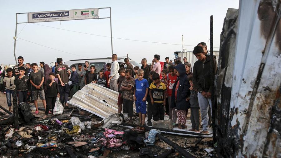 Palestinians look at the destruction after an Israeli strike where displaced people were staying in Rafah, Gaza Strip, Monday, May 27, 2024. Palestinian health workers said Israeli airstrikes killed at least 35 people in the area. Israel's army confirmed Sunday's strike and said it hit a Hamas installation and killed two senior Hamas militants. (AP Photo/Jehad Alshrafi)