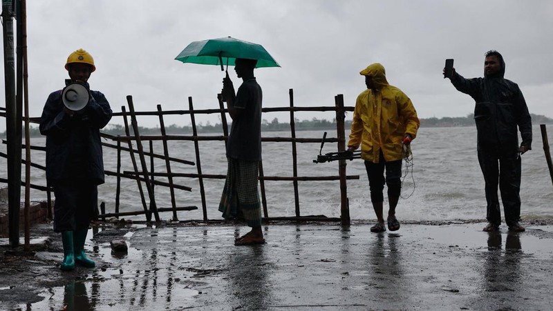 Seorang pria menyelamatkan gerobak dan material lainnya saat air mengalir ke pantai Kuakata di pesisir Teluk Benggala akibat mendekatnya Topan Remal di Barisal, Bangladesh, Minggu, 26 Mei 2024. (AP Photo/Abdul Goni)