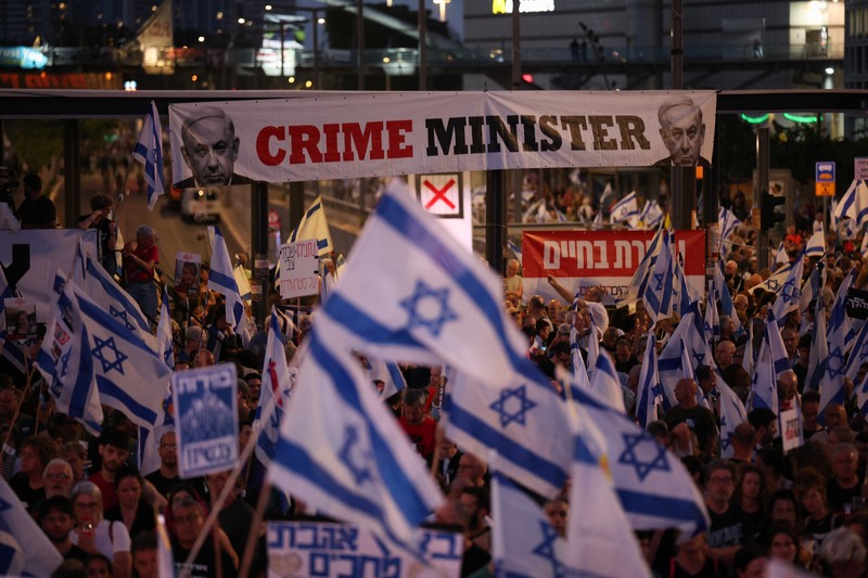 Seorang pengunjuk rasa menyalakan suar ketika mereka berdiri di dekat api yang menyala selama protes terhadap pemerintahan Perdana Menteri Israel Benjamin Netanyahu dan menyerukan pembebasan sandera yang diculik dalam serangan mematikan terhadap Israel pada 7 Oktober oleh kelompok Islam Palestina Hamas, di Tel Aviv , Israel, 25 Mei 2024. Seorang pengunjuk rasa menyalakan suar ketika mereka berdiri di dekat api yang menyala selama protes terhadap pemerintahan Perdana Menteri Israel Benjamin Netanyahu dan menyerukan pembebasan sandera yang diculik dalam serangan mematikan terhadap Israel pada 7 Oktober oleh kelompok Islam Palestina Hamas, di Tel Aviv , Israel, 25 Mei 2024. (REUTERS/Marko Djurica)