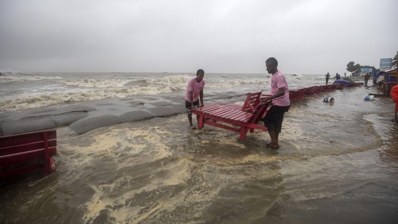 Seorang pria menyelamatkan gerobak dan material lainnya saat air mengalir ke pantai Kuakata di pesisir Teluk Benggala akibat mendekatnya Topan Remal di Barisal, Bangladesh, Minggu, 26 Mei 2024. (AP Photo/Abdul Goni)