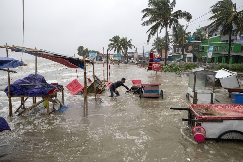 Seorang pria menyelamatkan gerobak dan material lainnya saat air mengalir ke pantai Kuakata di pesisir Teluk Benggala akibat mendekatnya Topan Remal di Barisal, Bangladesh, Minggu, 26 Mei 2024. Seorang pria menyelamatkan gerobak dan material lainnya saat air mengalir ke pantai Kuakata di pesisir Teluk Benggala akibat mendekatnya Topan Remal di Barisal, Bangladesh, Minggu, 26 Mei 2024. (AP Photo/Abdul Goni)