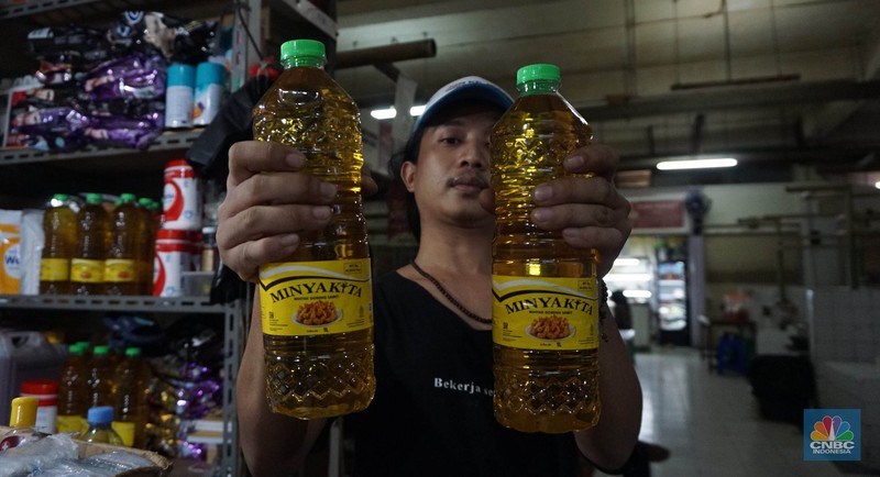 Sejumlah pedagang menunjukkan kemasan botol MinyakKita ukuran dua liter di Kawasan Pasar Santa, Jakarta Selatan, Selasa, (28/5). (CNBC Indonesia/Muhammad Sabki)