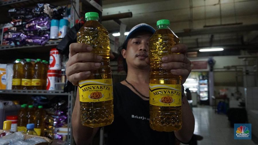 Sejumlah pedagang menunjukkan kemasan botol MinyakKita ukuran dua liter di Kawasan Pasar Santa, Jakarta Selatan, Selasa, (28/5). (CNBC Indonesia/Muhammad Sabki)