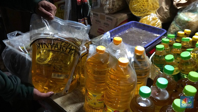 Sejumlah pedagang menunjukkan kemasan botol MinyakKita ukuran dua liter di Kawasan Pasar Santa, Jakarta Selatan, Selasa, (28/5). (CNBC Indonesia/Muhammad Sabki)