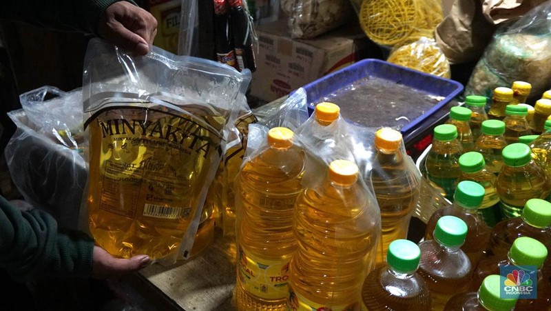 Sejumlah pedagang menunjukkan kemasan botol MinyakKita ukuran dua liter di Kawasan Pasar Santa, Jakarta Selatan, Selasa, (28/5). (CNBC Indonesia/Muhammad Sabki)
