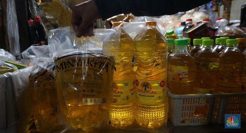 Sejumlah pedagang menunjukkan kemasan botol MinyakKita ukuran dua liter di Kawasan Pasar Santa, Jakarta Selatan, Selasa, (28/5). (CNBC Indonesia/Muhammad Sabki)