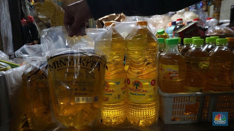 Sejumlah pedagang menunjukkan kemasan botol MinyakKita ukuran dua liter di Kawasan Pasar Santa, Jakarta Selatan, Selasa, (28/5). (CNBC Indonesia/Muhammad Sabki)
