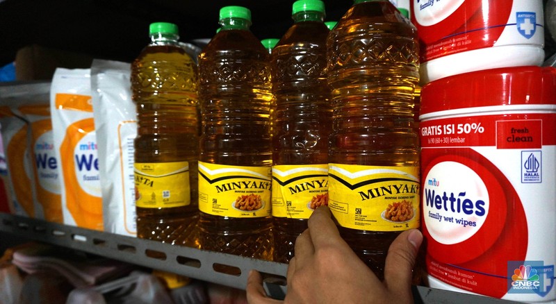 Sejumlah pedagang menunjukkan kemasan botol MinyakKita ukuran dua liter di Kawasan Pasar Santa, Jakarta Selatan, Selasa, (28/5). (CNBC Indonesia/Muhammad Sabki)