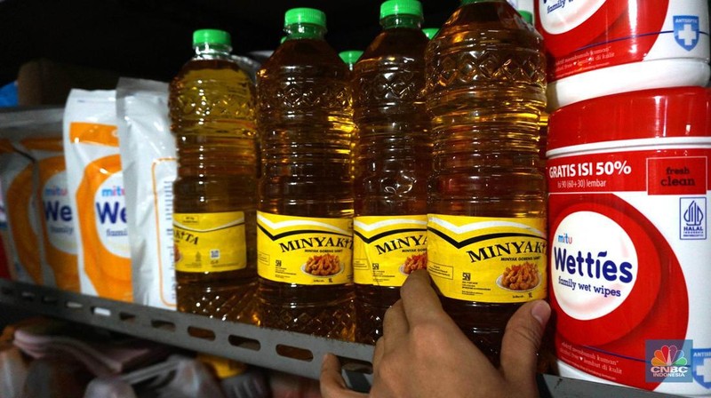 Sejumlah pedagang menunjukkan kemasan botol MinyakKita ukuran dua liter di Kawasan Pasar Santa, Jakarta Selatan, Selasa, (28/5). (CNBC Indonesia/Muhammad Sabki)