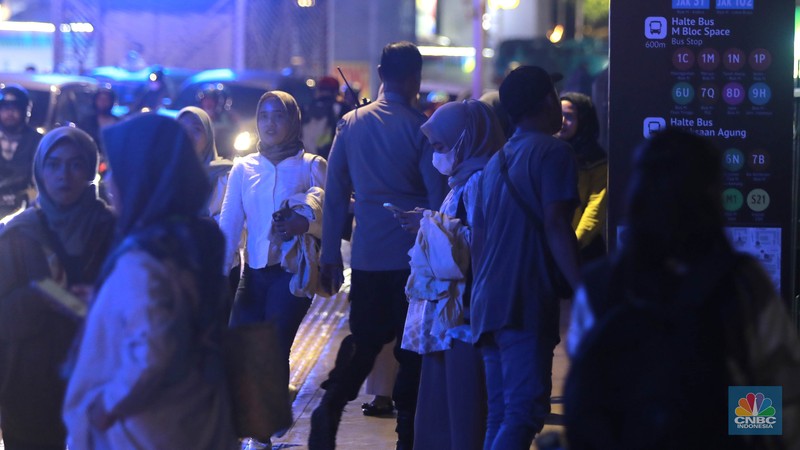 Sejumlah calon penumpangmelintas di sebelah Stasiun MRT di Blok M, Jakarta, Kamis, (30/5). Akses ke Stasiun MRT Blok M ditutup sementara setelah MRT menghentikan kegiatan operasionalnya sore ini. Penumpang pun menumpuk di sekitar Stasiun Blok M. (CNBC Indonesia/Muhammad Sabki)