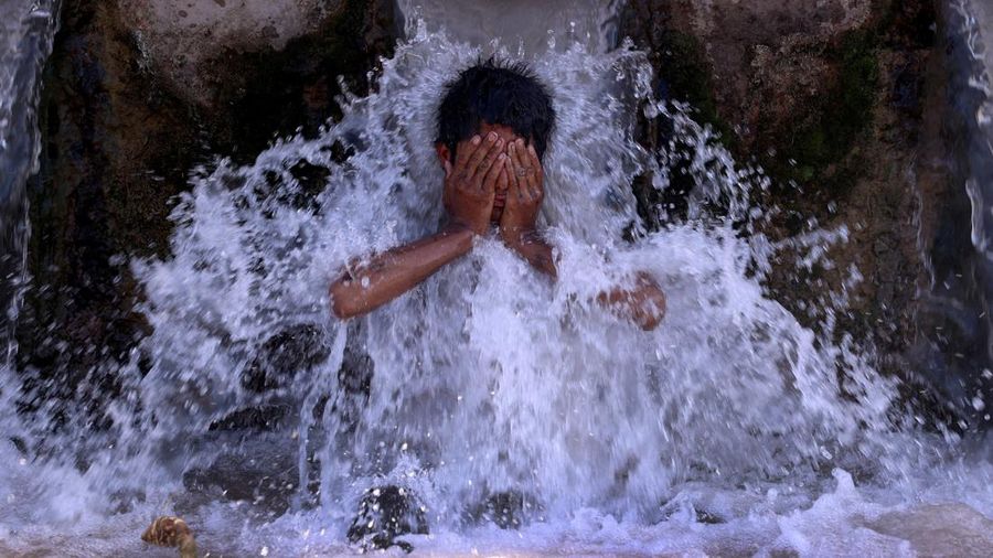 Para buruh tidur di pinggir jalan pada pagi hari musim panas yang terik di Karachi, Pakistan, Rabu (29/5/2024). (AP Photo/Fareed Khan)