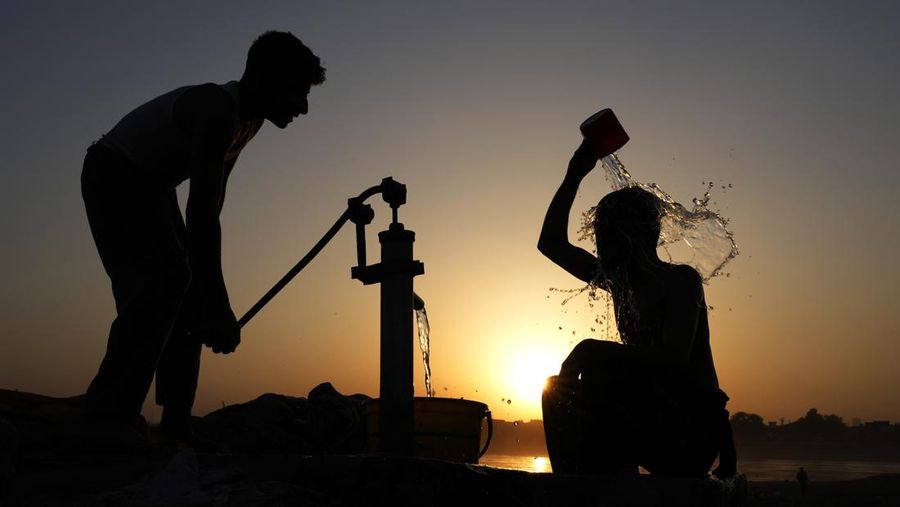 Para buruh tidur di pinggir jalan pada pagi hari musim panas yang terik di Karachi, Pakistan, Rabu (29/5/2024). (AP Photo/Fareed Khan)