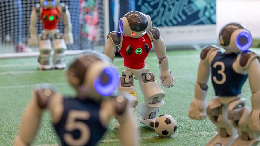 Robot Nao dari tim Nomadz, yang diprogram oleh ETHZ dan Insait Bulgaria, bermain sepak bola selama KTT AI for Good Global tentang kecerdasan buatan, yang diselenggarakan oleh International Telecommunication Union (ITU), di Jenewa, Swiss., Kamis (30/5/2024). (REUTERS/Denis Balibouse)
