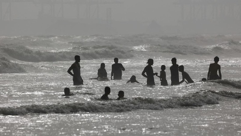 Warga bermain air saat cauca panas di Pantai Clifton, Karachi, Pakistan, Sabtu (1/6/2024). (REUTERS/Akhtar Soomro)