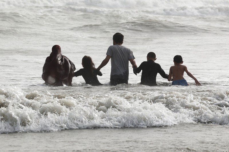 Warga bermain air saat cauca panas di Pantai Clifton, Karachi, Pakistan, Sabtu (1/6/2024). (REUTERS/Akhtar Soomro)