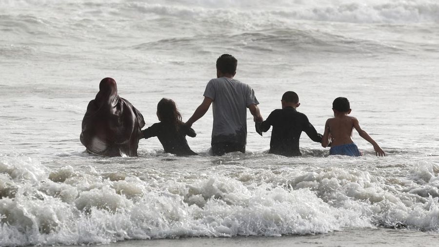 Warga bermain air saat cauca panas di Pantai Clifton, Karachi, Pakistan, Sabtu (1/6/2024). (REUTERS/Akhtar Soomro)