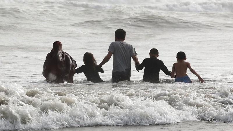 Warga bermain air saat cauca panas di Pantai Clifton, Karachi, Pakistan, Sabtu (1/6/2024). (REUTERS/Akhtar Soomro)