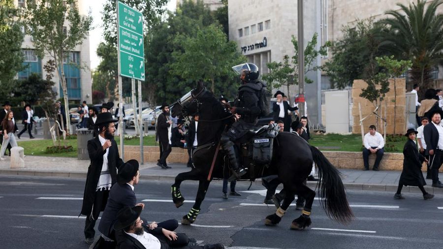 Pasukan keamanan beroperasi ketika para pria Yahudi Ultra-Ortodoks melakukan protes setelah Mahkamah Agung Israel bersidang untuk membahas petisi guna mengubah kebijakan pemerintah yang memberikan pengecualian kepada orang-orang Yahudi ultra-Ortodoks dari wajib militer, di tengah konflik yang sedang berlangsung di Gaza antara Israel dan kelompok Islam Palestina Hamas, dekat dengan Mahkamah Agung Israel. Pengadilan di Yerusalem, 2 Juni 2024. (REUTERS/Ronen Zvulun)