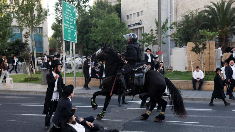 Pasukan keamanan beroperasi ketika para pria Yahudi Ultra-Ortodoks melakukan protes setelah Mahkamah Agung Israel bersidang untuk membahas petisi guna mengubah kebijakan pemerintah yang memberikan pengecualian kepada orang-orang Yahudi ultra-Ortodoks dari wajib militer, di tengah konflik yang sedang berlangsung di Gaza antara Israel dan kelompok Islam Palestina Hamas, dekat dengan Mahkamah Agung Israel. Pengadilan di Yerusalem, 2 Juni 2024. (REUTERS/Ronen Zvulun)