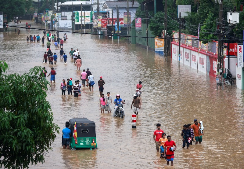Penduduk desa berjalan melalui jalan yang banjir di Biyagama, Sri Lanka 2 Juni 2024. (REUTERS/Dinuka Liyanawatte)