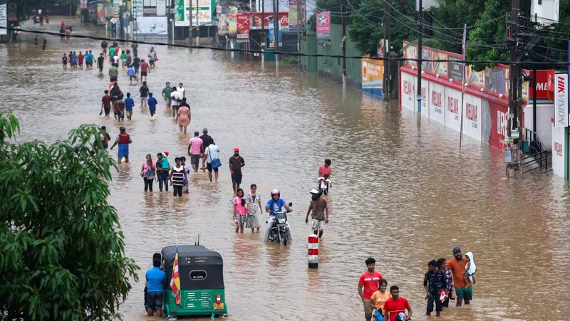 Penduduk desa berjalan melalui jalan yang banjir di Biyagama, Sri Lanka 2 Juni 2024. (REUTERS/Dinuka Liyanawatte)